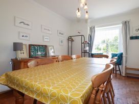 A dining room with a table and chairs at Trevethen Cottage in Crantock