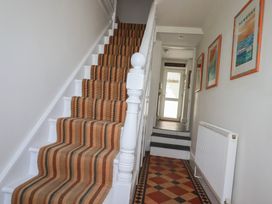 A hallway with stairs and a door at Trevethen Cottage in Crantock