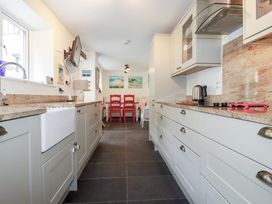 A kitchen featuring cabinets and a sink at Trevethen Cottage in Crantock