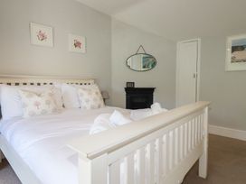 A bedroom with a bed and decor at Trevethen Cottage in Crantock