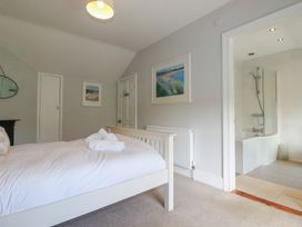 A bedroom with a bed and adjoining bathroom at Trevethen Cottage, Crantock