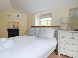 A bedroom with a bed and dresser at Trevethen Cottage in Crantock