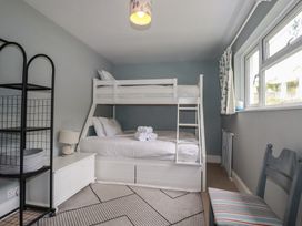 A bedroom with a bunk bed and a double bed at Trevethen Cottage in Crantock