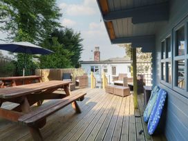 An outdoor deck with seating and a table at Trevethen Cottage in Crantock