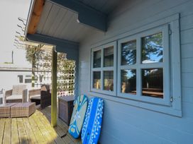 An outdoor area with furniture and surfboards at Trevethen Cottage in Crantock