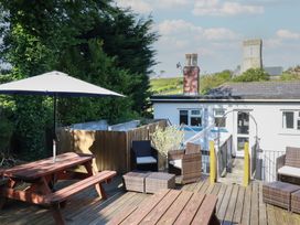 An outdoor seating area with a table and chairs at Trevethen Cottage Crantock