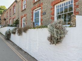 A house with windows and a wall decorated with plants at Trevethan Cottage in Crantock