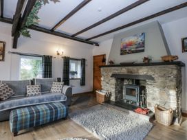 A living room with a fireplace and sofas at Ty Gwennol in Llanfaethlu