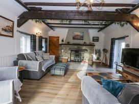 A living room with a fireplace and furniture at Ty Gwennol in Llanfaethlu