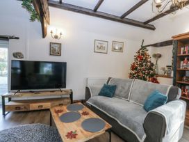 A living room with a sofa and television at Ty Gwennol in Llanfaethlu