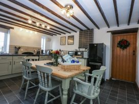 A kitchen with a table and chairs at Ty Gwennol in Llanfaethlu