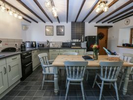 A kitchen with a table and chairs at Ty Gwennol in Llanfaethlu