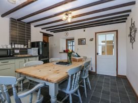 A kitchen with a dining table and appliances at Ty Gwennol in Llanfaethlu