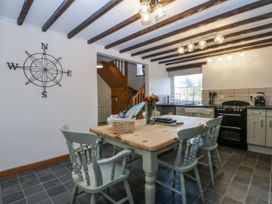 A kitchen with a table and chairs at Ty Gwennol in Llanfaethlu