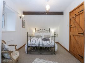 A bedroom with a bed and chair at Ty Gwennol in Llanfaethlu