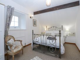 A bedroom with a bed and chair at Ty Gwennol in Llanfaethlu