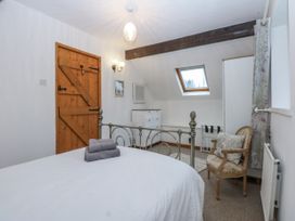 A bedroom with a bed and wooden door at Ty Gwennol in Llanfaethlu