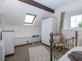 A bedroom with a bed, wardrobe, and chair at Ty Gwennol in Llanfaethlu