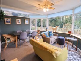 A conservatory with seating and dining area at Yewbarrow Cottage in Grange-Over-Sands
