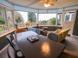 A conservatory with a table and chairs at Yewbarrow Cottage in Grange-Over-Sands