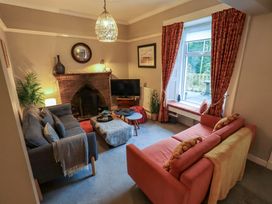 A living room with a sofa, tv, and fireplace at Yewbarrow Cottage in Grange-Over-Sands