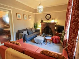 A living room with a fireplace and sofa at Yewbarrow Cottage in Grange-Over-Sands