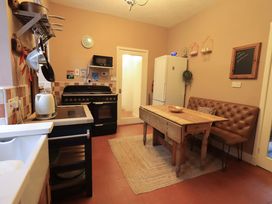 A kitchen with a table and chairs at Yewbarrow Cottage in Grange-Over-Sands