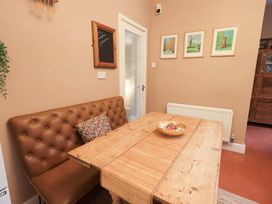 A dining room with a table and bench seating at Yewbarrow Cottage in Grange-Over-Sands