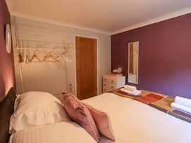 A bedroom with a bed and a clothes rack at Yewbarrow Cottage in Grange-Over-Sands
