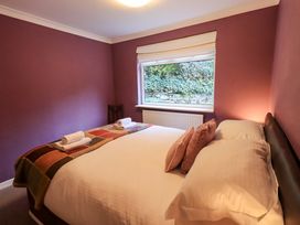 A bedroom with a bed and window at Yewbarrow Cottage Grange-Over-Sands