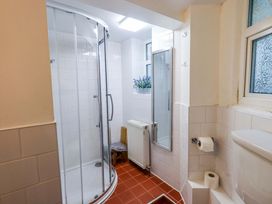 A bathroom with a shower, toilet and mirror at Yewbarrow Cottage in Grange-Over-Sands