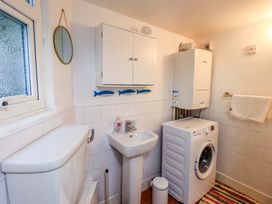 A bathroom with a washing machine and a sink at Yewbarrow Cottage in Grange-Over-Sands