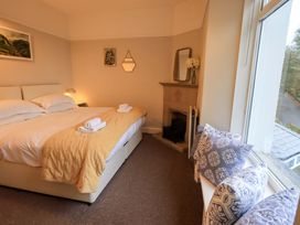 A bedroom with a bed and a fireplace at Yewbarrow Cottage Grange-Over-Sands