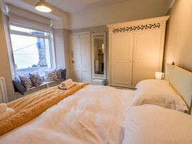 A bedroom with a bed and wardrobe at Yewbarrow Cottage in Grange-Over-Sands