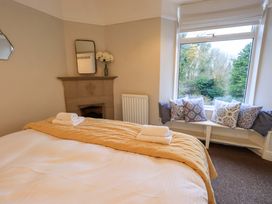 A bedroom with a bed and window seat at Yewbarrow Cottage in Grange-Over-Sands