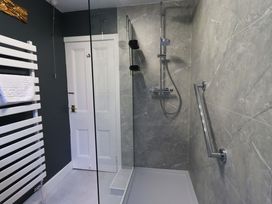 A bathroom with a shower and towel rail at Yewbarrow Cottage in Grange-Over-Sands