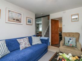 A living room with a blue sofa and small table at 3 Rock Cottages in Kingston