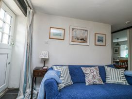 A living room with a sofa and paintings at 3 Rock Cottages Kingston