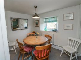 A dining room with a wooden table and chairs at 3 Rock Cottages in Kingston