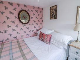A bedroom with a bed and wall art at 3 Rock Cottages Kingston