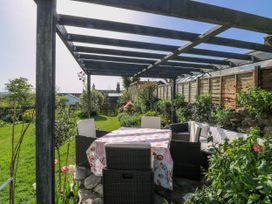 A garden with a table and chairs under a pergola at 3 Rock Cottages Kingston