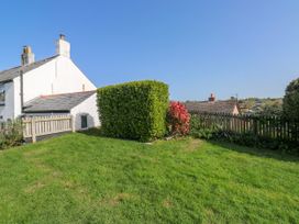 A garden with a hedge and flowers at 3 Rock Cottages Kingston