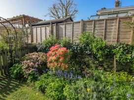 A garden with flowers and a fence at 3 Rock Cottages in Kingston