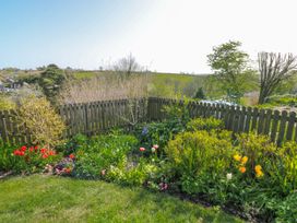 A garden with flowers and a wooden fence at 3 Rock Cottages in Kingston