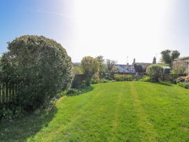 A garden with grass and bushes at 3 Rock Cottages in Kingston