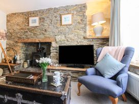 A living room with a stone wall and fireplace at 3 Rock Cottages in Kingston