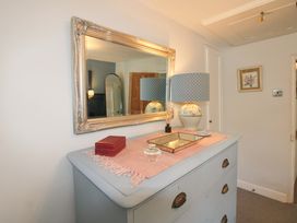 A hallway with a mirror and lamp on a table at 3 Rock Cottages Kingston
