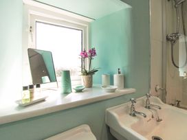 A bathroom with a sink and window at 3 Rock Cottages Kingston