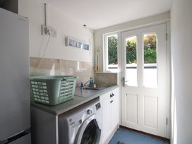 A laundry room with washing machine and sink at 3 Rock Cottages in Kingston