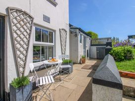 An outdoor patio area with a table and chairs at 3 Rock Cottages Kingston